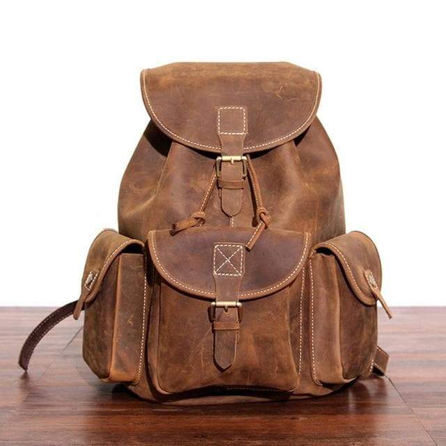 Light Brown Acadia Leather backpack front view standing upright showing four large pockets for storage