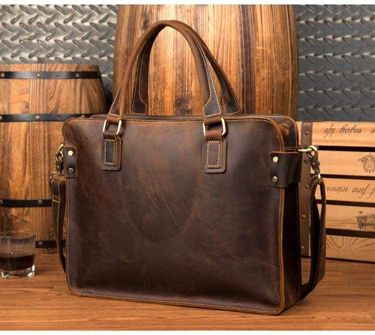 Bryce dark brown leather briefcase upright position back view against wooden casks on wooden table