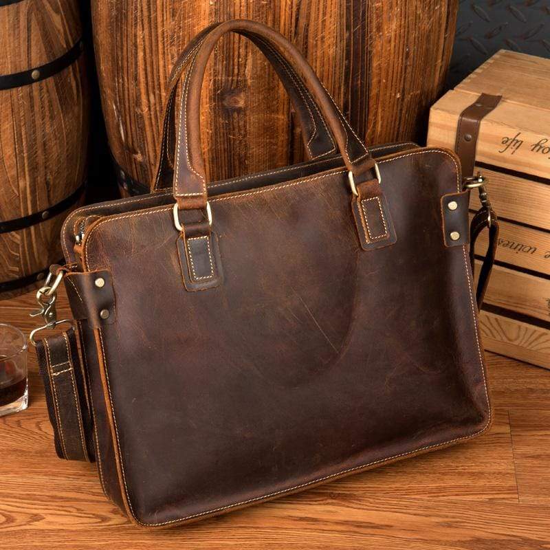 Bryce leather briefcase dark brown front view on a wooden table with a wooden cask next to it