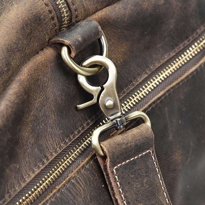 Close up shot of brass clasp on the dark brown Carter weekender duffle bag