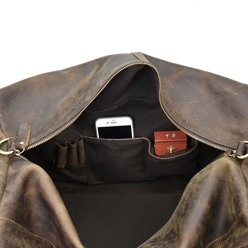 Carter leather duffle bag open showing iPhone and pack of playing cards in side pocket