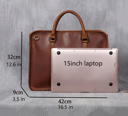 Lyndon laptop leather briefcase upright position showing a 15" laptop leaning against it on a gray canvas background