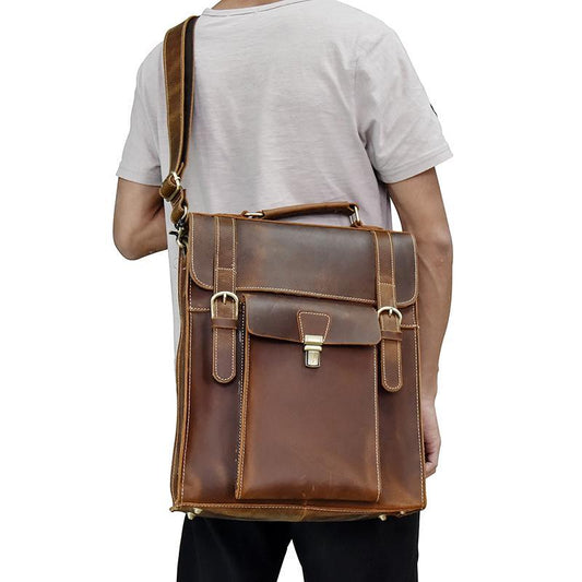 Man with white t-shirt carrying a Badlands leather backpack light brown in color and carrying it as a shoulder bag