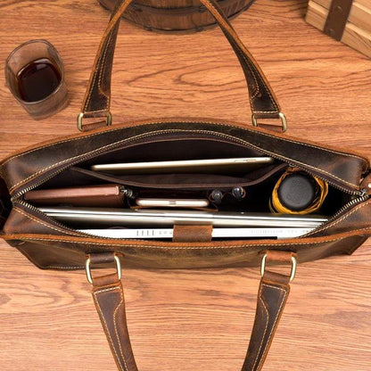 Open view of Bryce leather dark brown briefcase showing contents of laptop computer, pens, books and iPhone