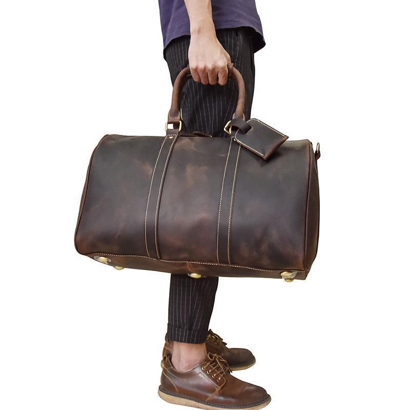 Man with black jeans and purple shirt standing with Yukon Weekender Duffle bag side view on a white background