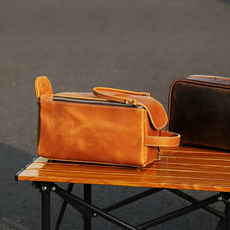 Dopp kit and men's toiletry bag on wooden table